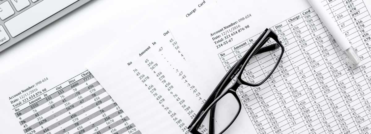 A table with accounting charts and a pair of glasses.