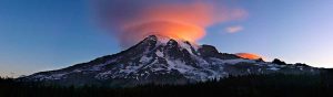 A lenticular cloud circles the summit of Mount Rainier at sunset