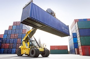 A forklift transports an empty container at a port dock