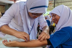 A nurse immunizes a child in a small community clinic.