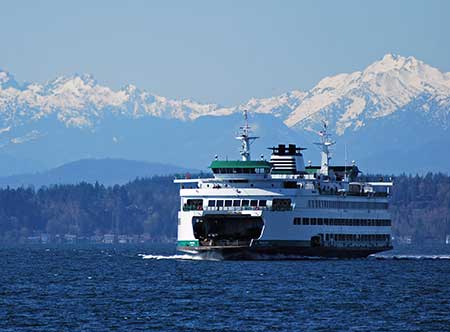 A Washington State ferry passes in front of the Olympic Mountains