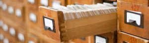 A single drawer of a library card catalog remains open