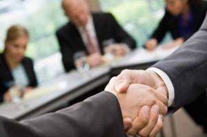 Two businessman shake hands at a meeting