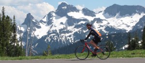 A bicyclist races past Mount Rainier on his bicycle