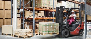 A forklift carries a pallet of goods in a fulfillment warehouse