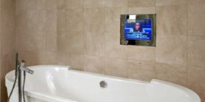 A bathroom with a television behind a mirror, built by Electric Mirror in Everett, Washington