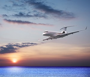 A Gulfstream jet flies low over the water on approach to an airport