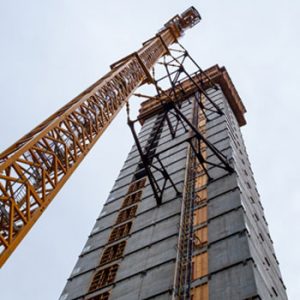 A construction crane rises next to a new high rise being built in Seattle.