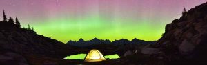Campers in a tent enjoy the view in the Cascades of the Northern Lights on a clear night