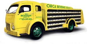 A yellow and green Orca Beverage truck that is being restored