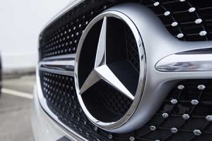 The Mercedes-Benz logo adorns the front of a new car.