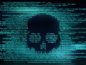 A skull appears on a screen of code, representing a cyber or ransomeware attack.